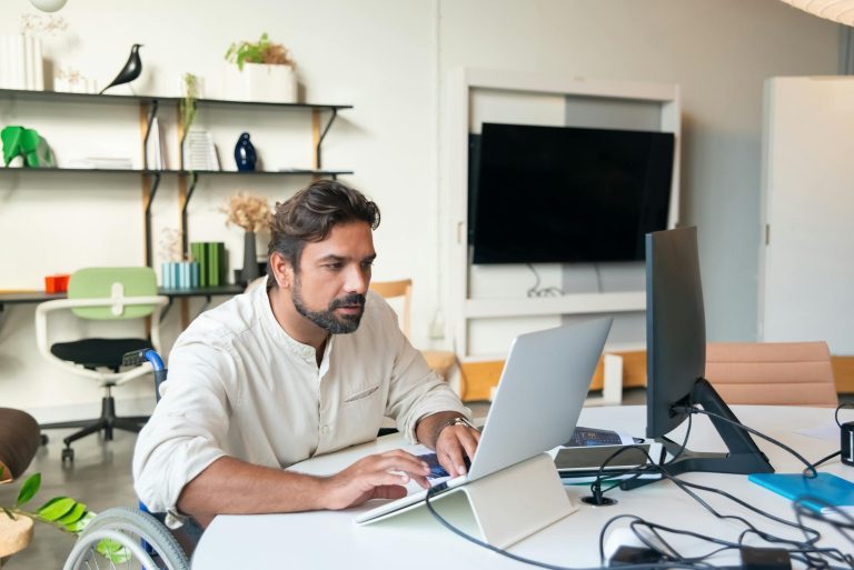 Compensation salaire RQTH quelles aides — travailleur handicapé au bureau avec ordinateur